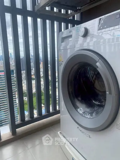 High-rise balcony with washing machine and city skyline view, perfect for urban living.