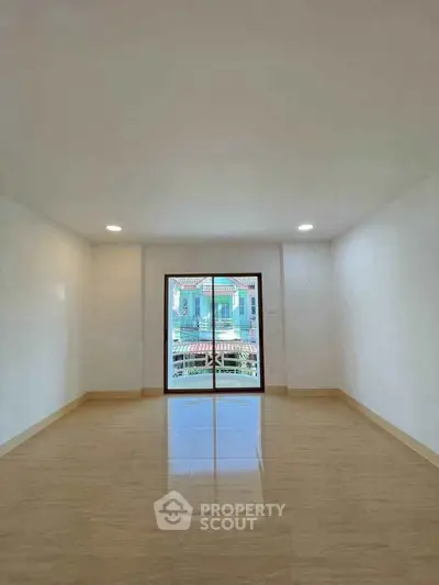 Spacious empty room with large window and tiled floor, perfect for customization.