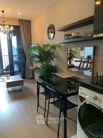 Modern living room with stylish decor and balcony view, featuring a washing machine and elegant lighting.