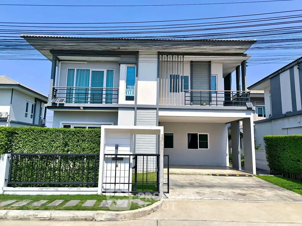Modern two-story house with sleek design and spacious driveway in a suburban neighborhood.