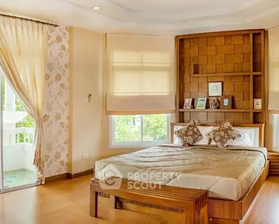 Elegant bedroom with wooden accents and large windows offering natural light