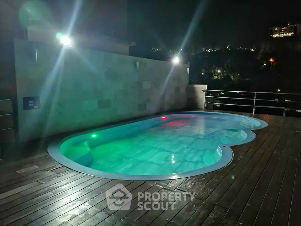Luxurious rooftop pool with ambient lighting and stunning night view.