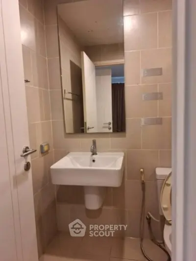 Compact bathroom with modern sink and toilet in neutral tones