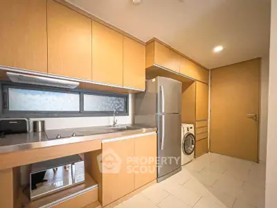 Modern kitchen with sleek cabinetry, stainless steel appliances, and washer-dryer combo.