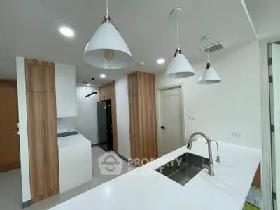 Modern kitchen with sleek white countertops and stylish pendant lighting