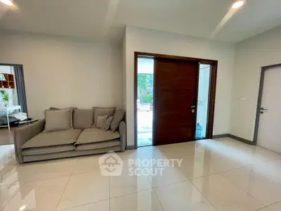 Spacious living room with modern sofa and large wooden door