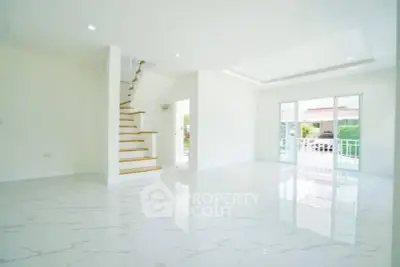 Spacious modern living room with marble flooring and staircase