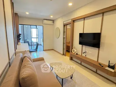 Modern living room with stylish decor and wall-mounted TV in a cozy apartment.