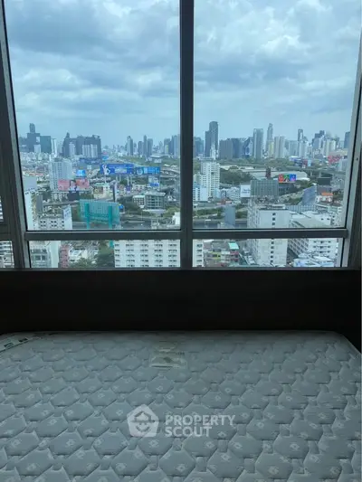 Stunning cityscape view from high-rise apartment bedroom window.