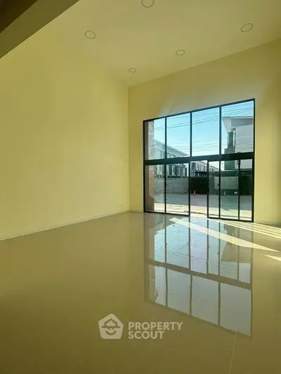 Spacious living room with high ceilings and large windows offering abundant natural light.