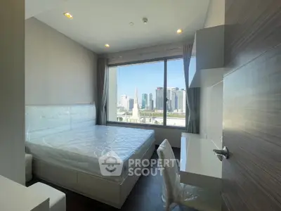 Modern bedroom with city view, featuring large window and sleek furnishings.