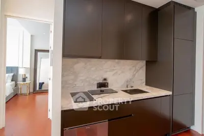 Modern kitchen with sleek cabinetry and marble backsplash in luxury apartment