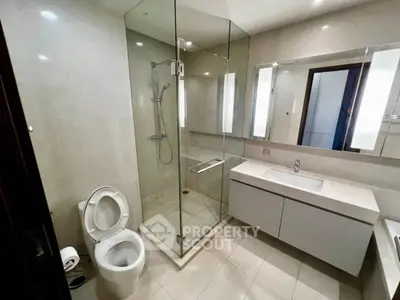 Modern bathroom with glass shower and sleek vanity in luxury apartment
