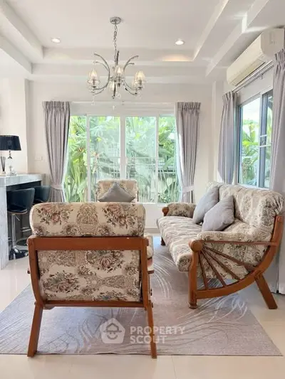 Charming living room with elegant floral furniture and natural light, perfect for relaxation.