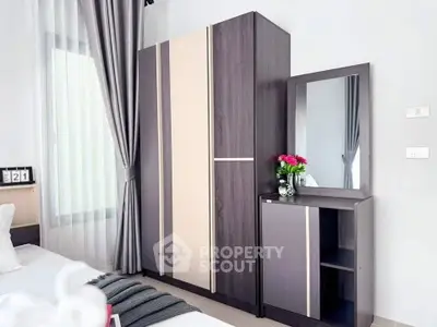 Modern bedroom with stylish wardrobe and mirror, elegant curtains, and cozy decor.