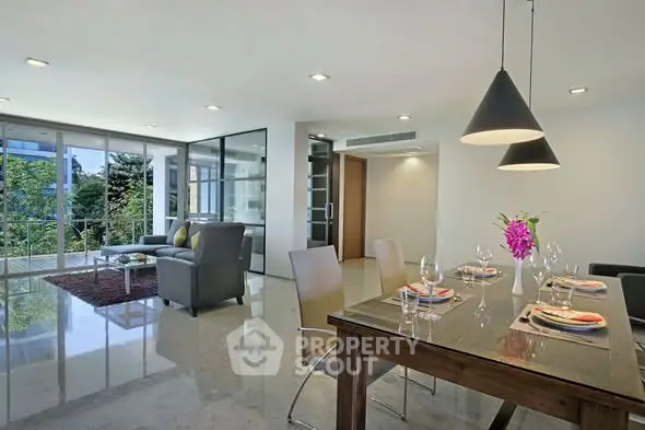Spacious modern living room with dining area and large windows offering a lush garden view.