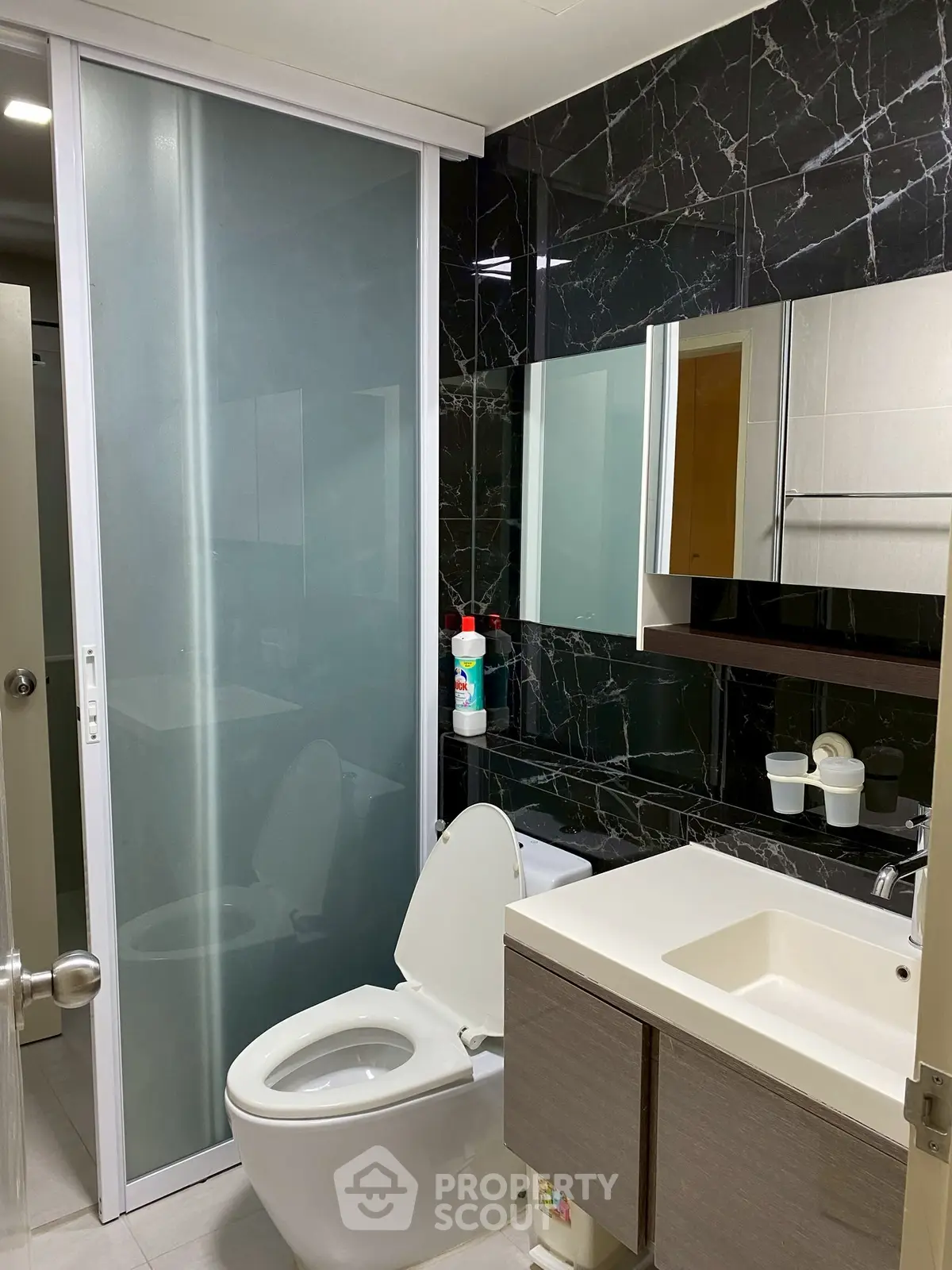 Modern bathroom with sleek black marble tiles and contemporary fixtures.