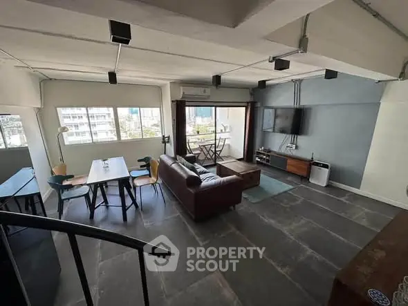 Modern industrial-style living room with open layout and city view.