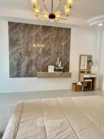 Elegant bedroom with marble accent wall and stylish chandelier