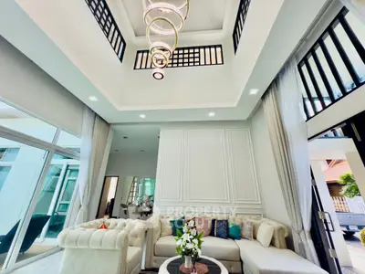 Luxurious living room with high ceiling and elegant chandelier in modern home