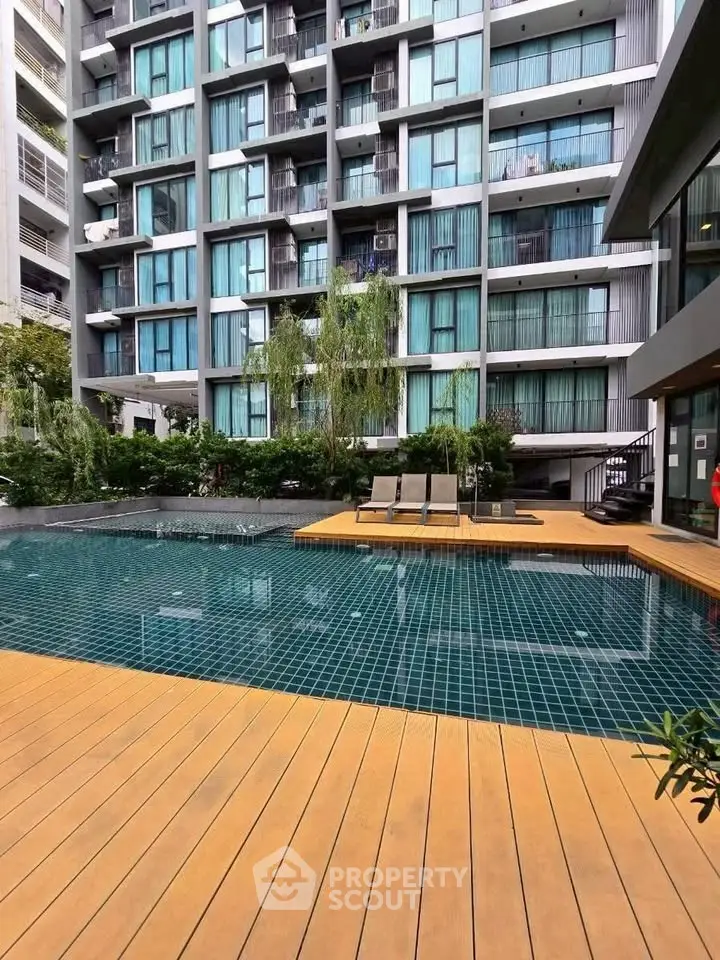 Modern apartment building with a stylish pool and sun deck, perfect for relaxation and leisure.