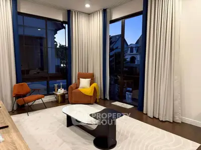 Elegant living room with modern furniture and large windows offering a serene view.