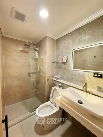 Modern bathroom with glass shower and elegant fixtures in a stylish apartment.