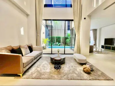 Luxurious living room with high ceilings and pool view, featuring elegant furniture and modern decor.