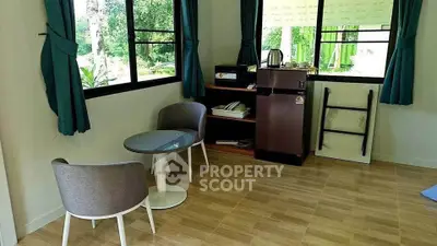 Cozy living room with modern chairs, glass table, and scenic window views.