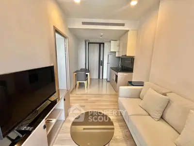 Modern living room with sleek furniture and open kitchen layout in a stylish apartment.