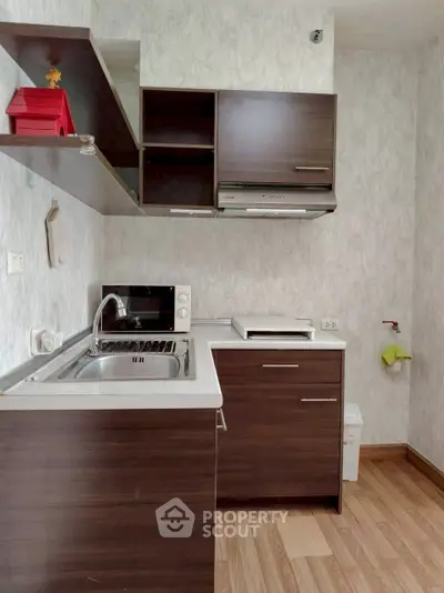 Compact modern kitchen with dark wood cabinets and sleek appliances