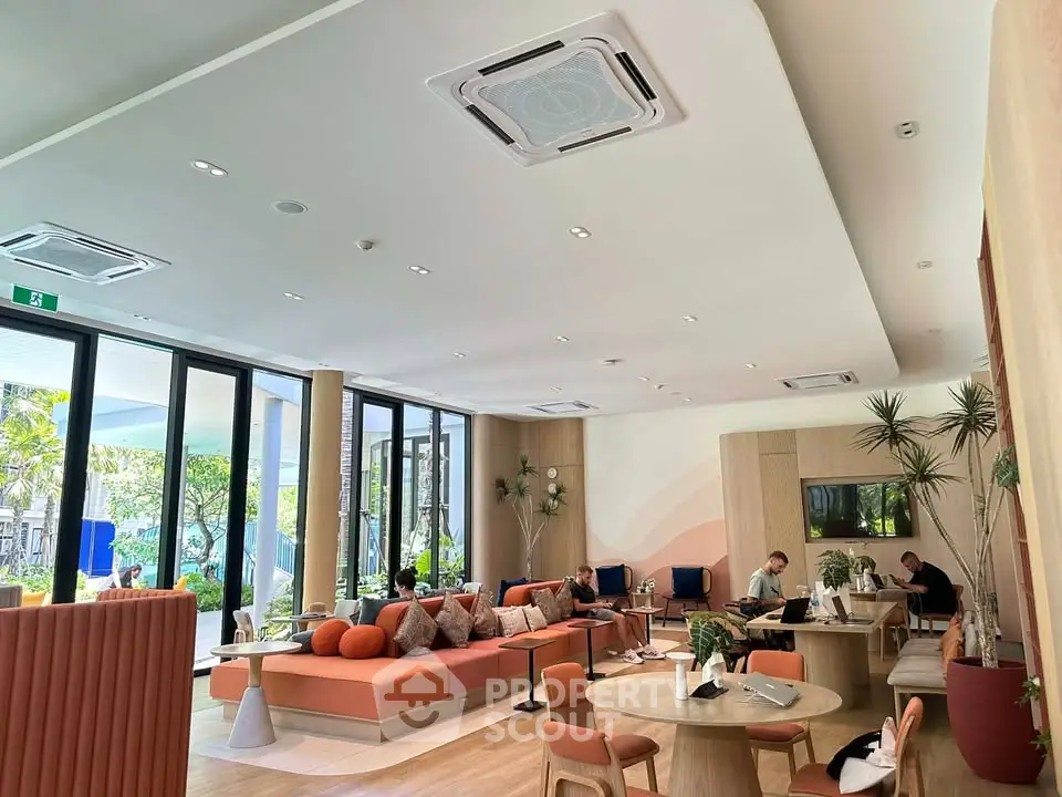 Modern living room with stylish furniture and large windows overlooking a garden.