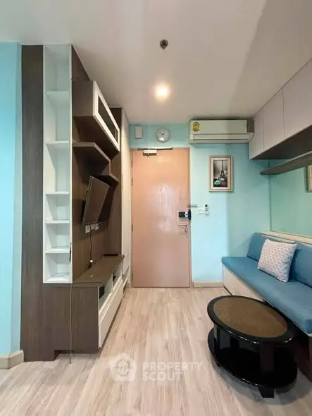 Modern living room with stylish furniture and wall-mounted TV in a cozy apartment.