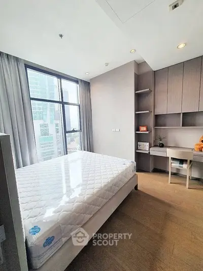 Modern bedroom with large window and built-in desk in high-rise apartment