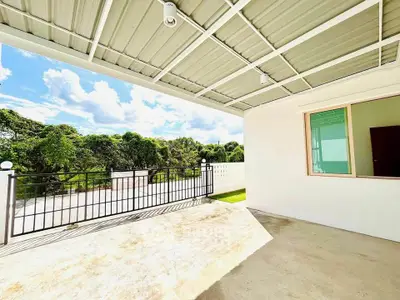 Spacious covered patio with scenic garden view and modern design.