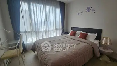 Cozy bedroom with large window and modern decor in a stylish apartment.