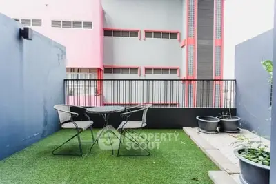 Modern balcony with artificial grass and stylish outdoor seating
