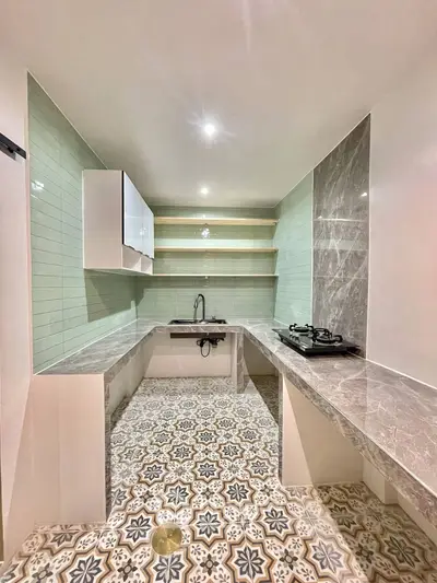 Modern kitchen with stylish tile flooring and sleek countertops, featuring a gas stove and open shelving.