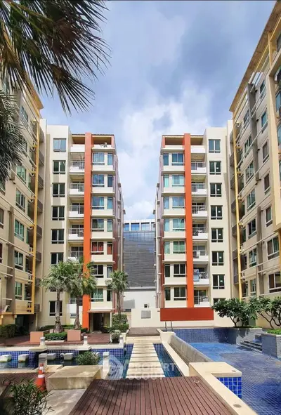 Modern apartment complex with pool and landscaped courtyard, ideal urban living.