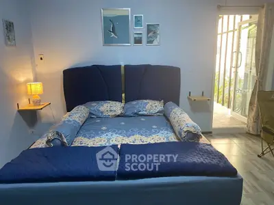 Cozy bedroom with elegant blue decor and balcony access, perfect for relaxation and comfort.