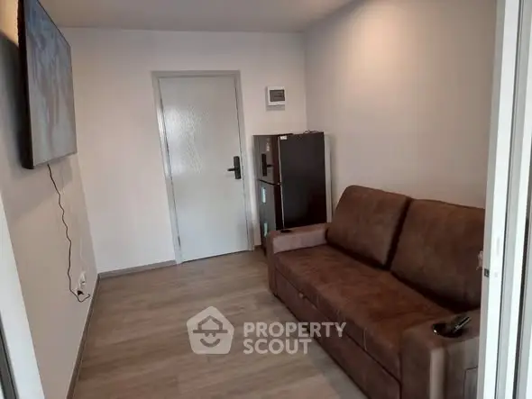 Cozy living room with brown sofa and wall-mounted TV, perfect for relaxation.