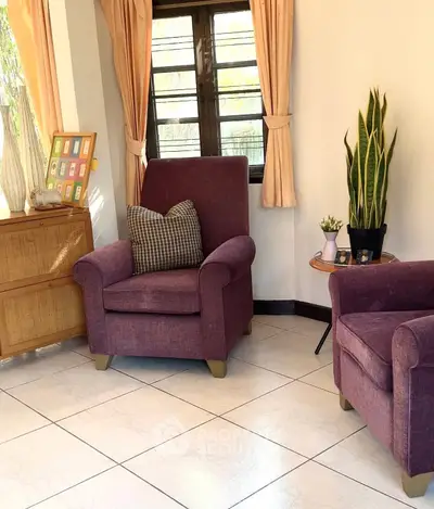 Cozy living room with plush purple armchairs and natural light