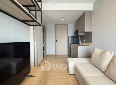 Modern studio apartment with sleek kitchen and cozy living area, perfect for urban living.