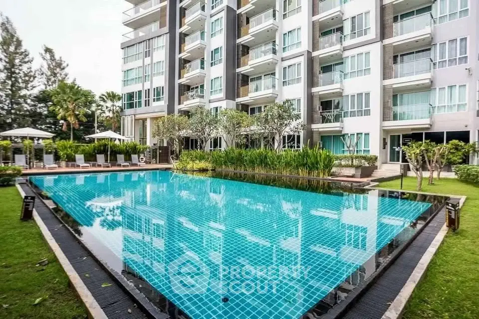 Luxurious condominium with a stunning outdoor pool and lush garden surroundings.