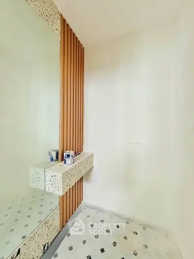 Modern bathroom with stylish terrazzo accents and geometric floor tiles.