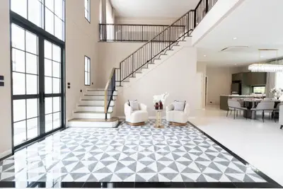 Luxurious modern living room with high ceilings and elegant staircase in a spacious open-plan design.