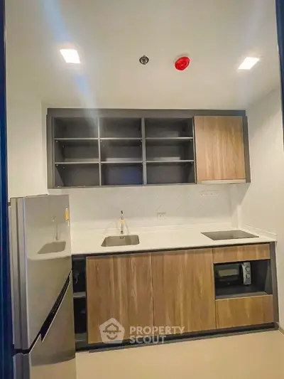 Modern kitchen with sleek cabinetry and stainless steel appliances in a contemporary apartment.