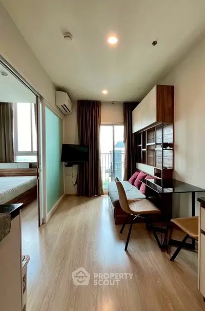 Modern living room with balcony view, stylish furniture, and natural light in a contemporary apartment.
