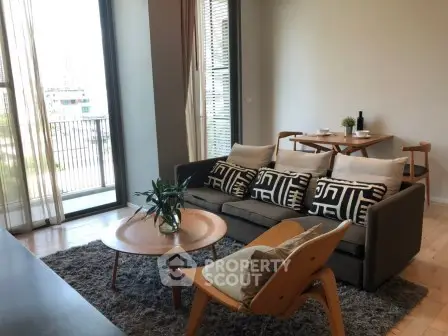 Stylish living room with modern furniture and balcony view in a chic apartment.