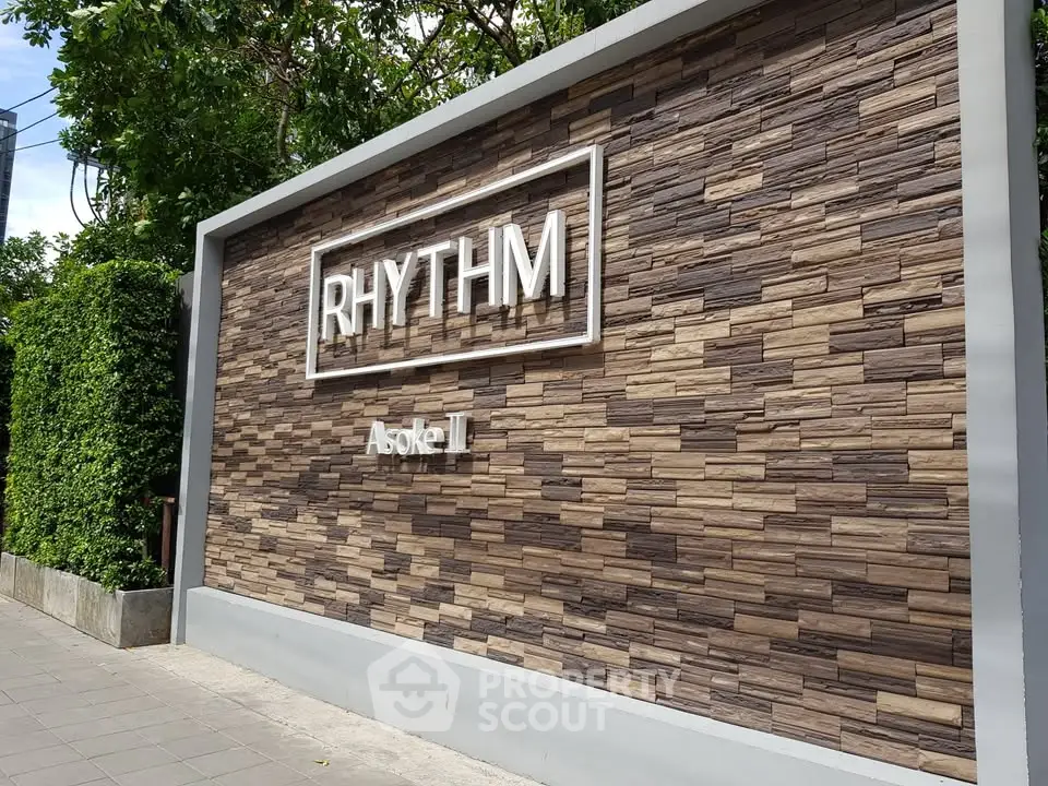 Modern exterior wall with Rhythm Asoke II signage in urban setting
